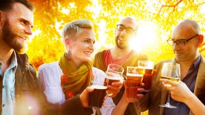 A community of drinkers cheers with their glasses