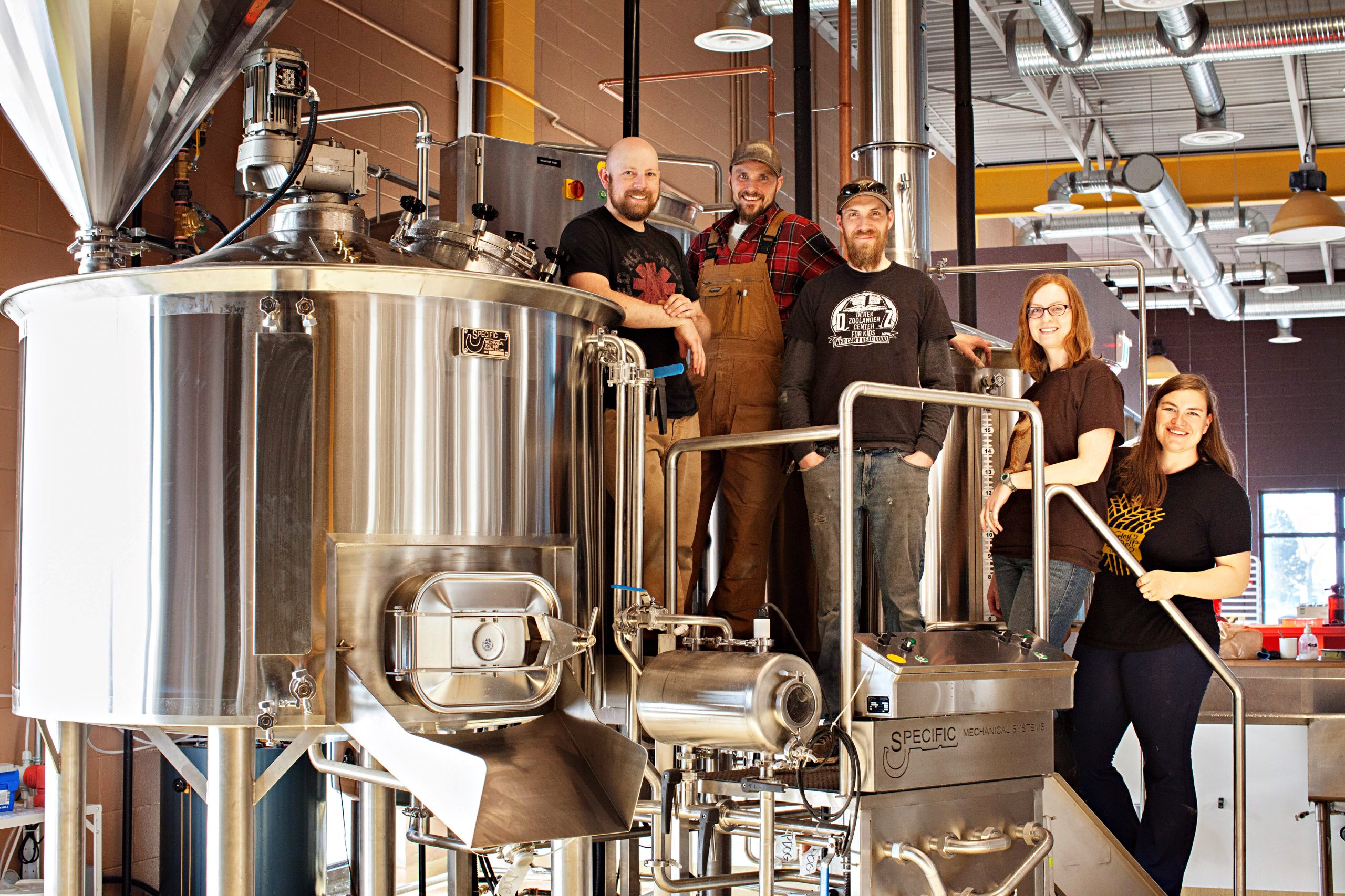 Prairie Dog Brewing founders stand on the brewhouse in their 58th Avenue Brewpub, a popular location for brewery tours.