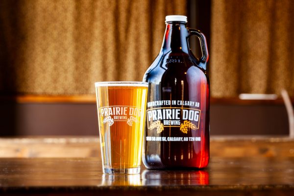 A 64-oz growler jug of Prairie Dog Brewing table saison, a pale, refreshing, flavourful and easy drinking beer with spicy and fruity notes.