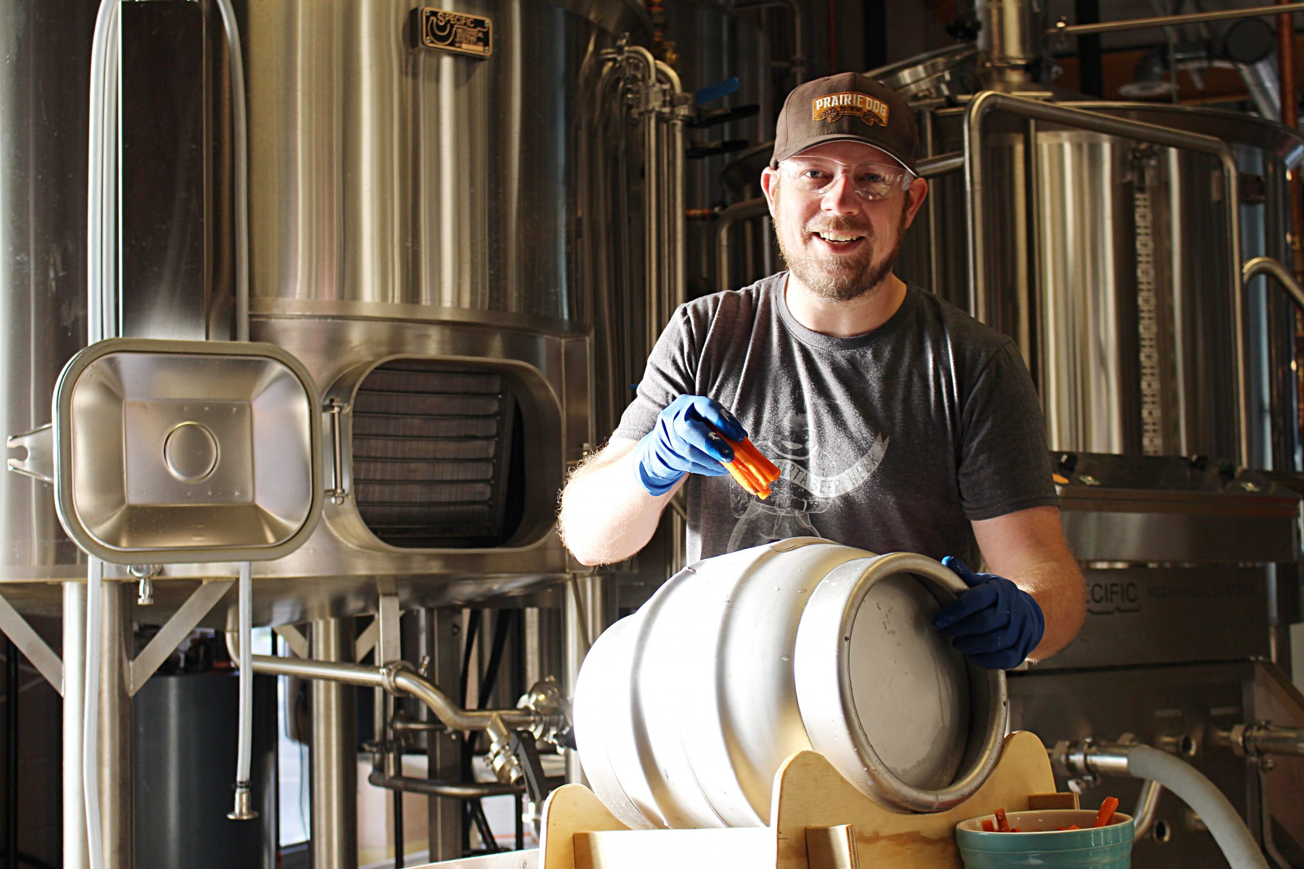 Founder/Brewmaster Gerad adds carrots to a cask of a special carrot-cake beer.