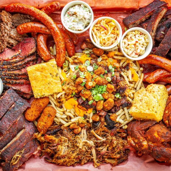 Prairie Dog Brewing's Way Too Much BBQ platter featuring smoked beef brisket, pastrami, ribs, chicken, pulled pork, sausage, sides and an Extreme Poutine.