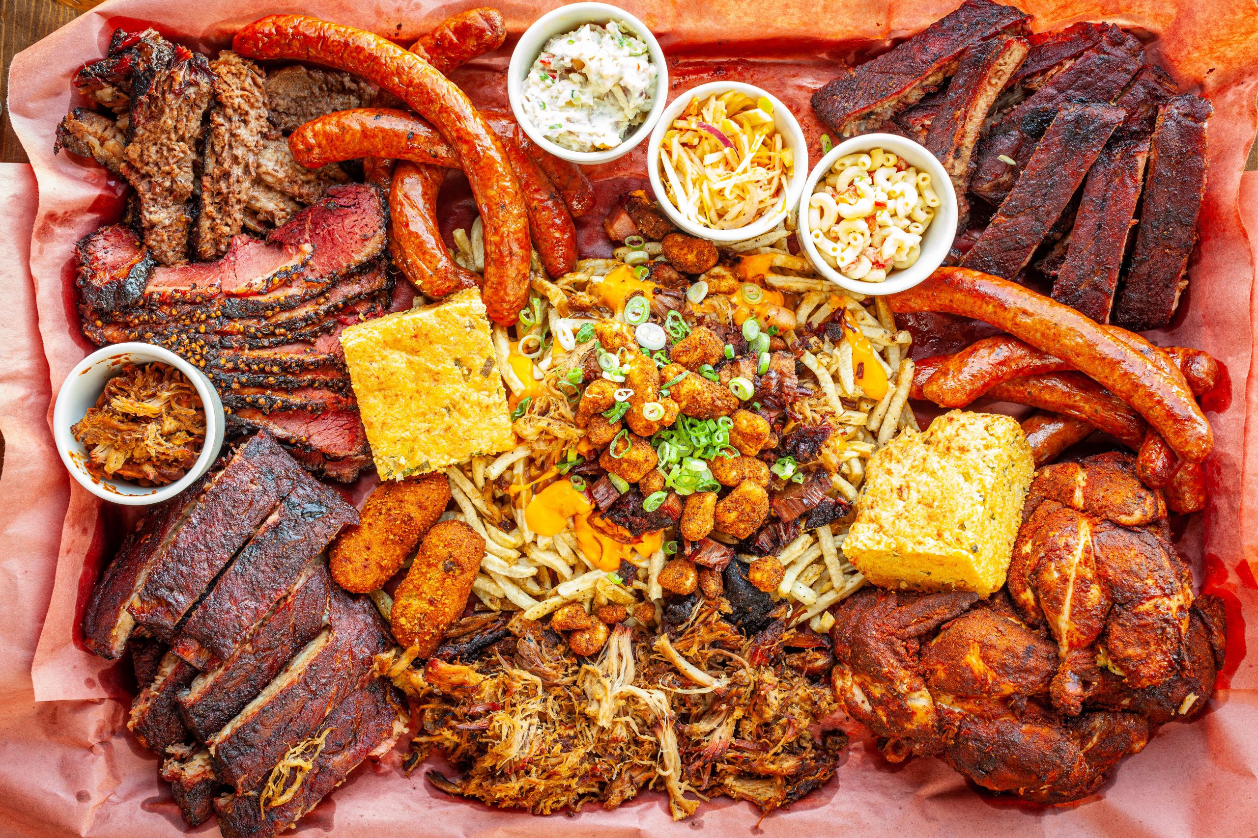 Prairie Dog Brewing's Way Too Much BBQ platter featuring smoked beef brisket, pastrami, ribs, chicken, pulled pork, sausage, sides and an Extreme Poutine.