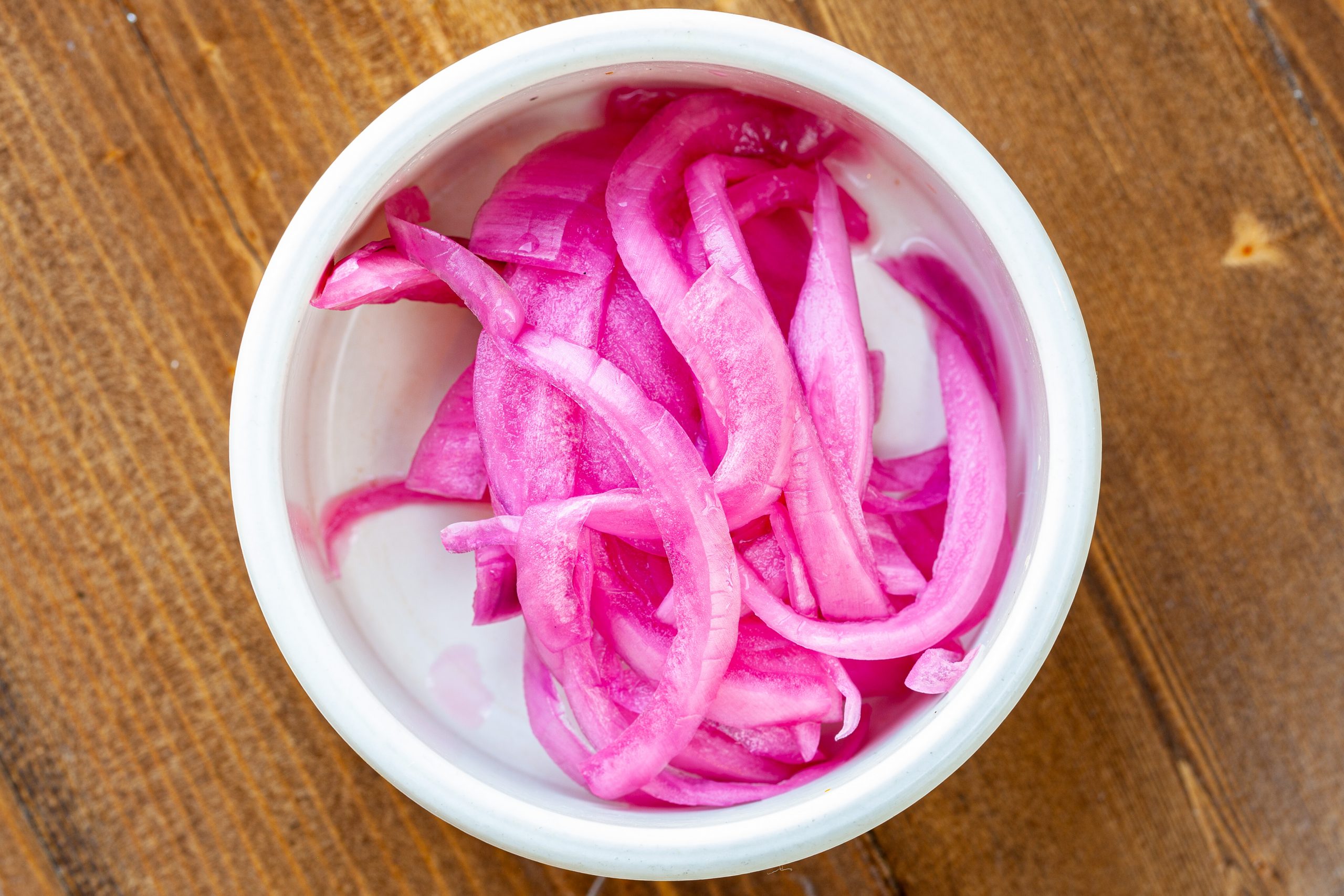 Pickled red onion slices in a side ramekin