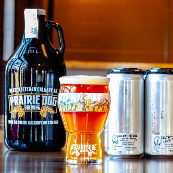 Prairie Dog Brewing's delicious Tail Twitcher west-coast-style IPA in a 16oz glass, 473mL cans and 64oz growler