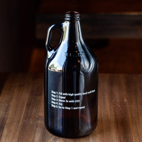 Rear side of 64-oz Prairie Dog Brewing branded glass growler jug for beer off-sales.