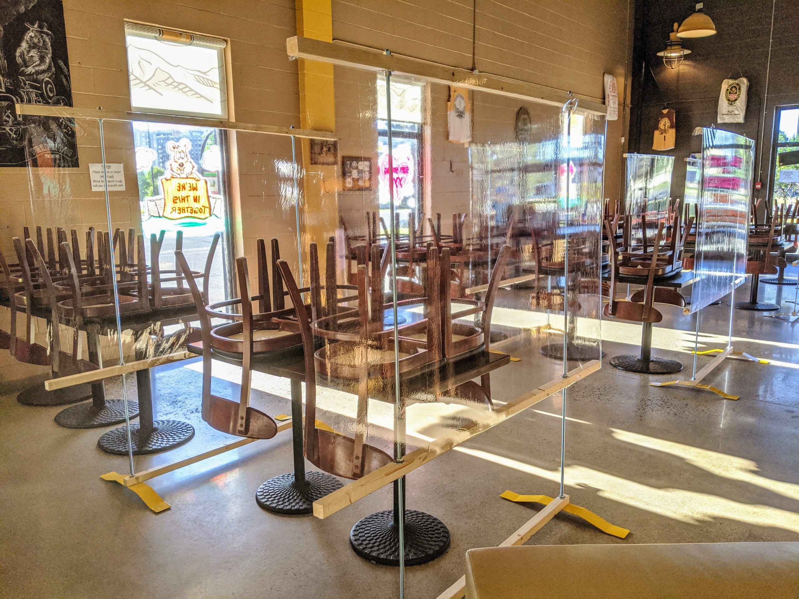 Low tables with mobile barrier solution in Prairie Dog Brewing dining room allow customers to reconnect with an extra margin of safety against SARS-CoV-2.