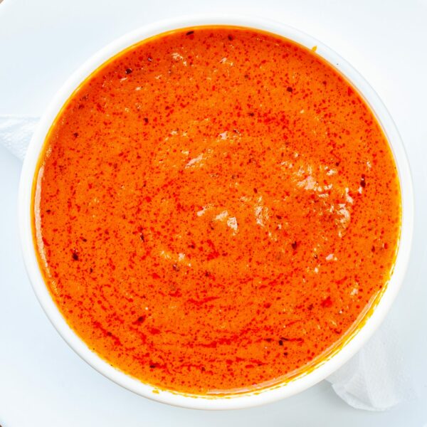 Side tomato, roasted red pepper and Gouda soup in a bowl