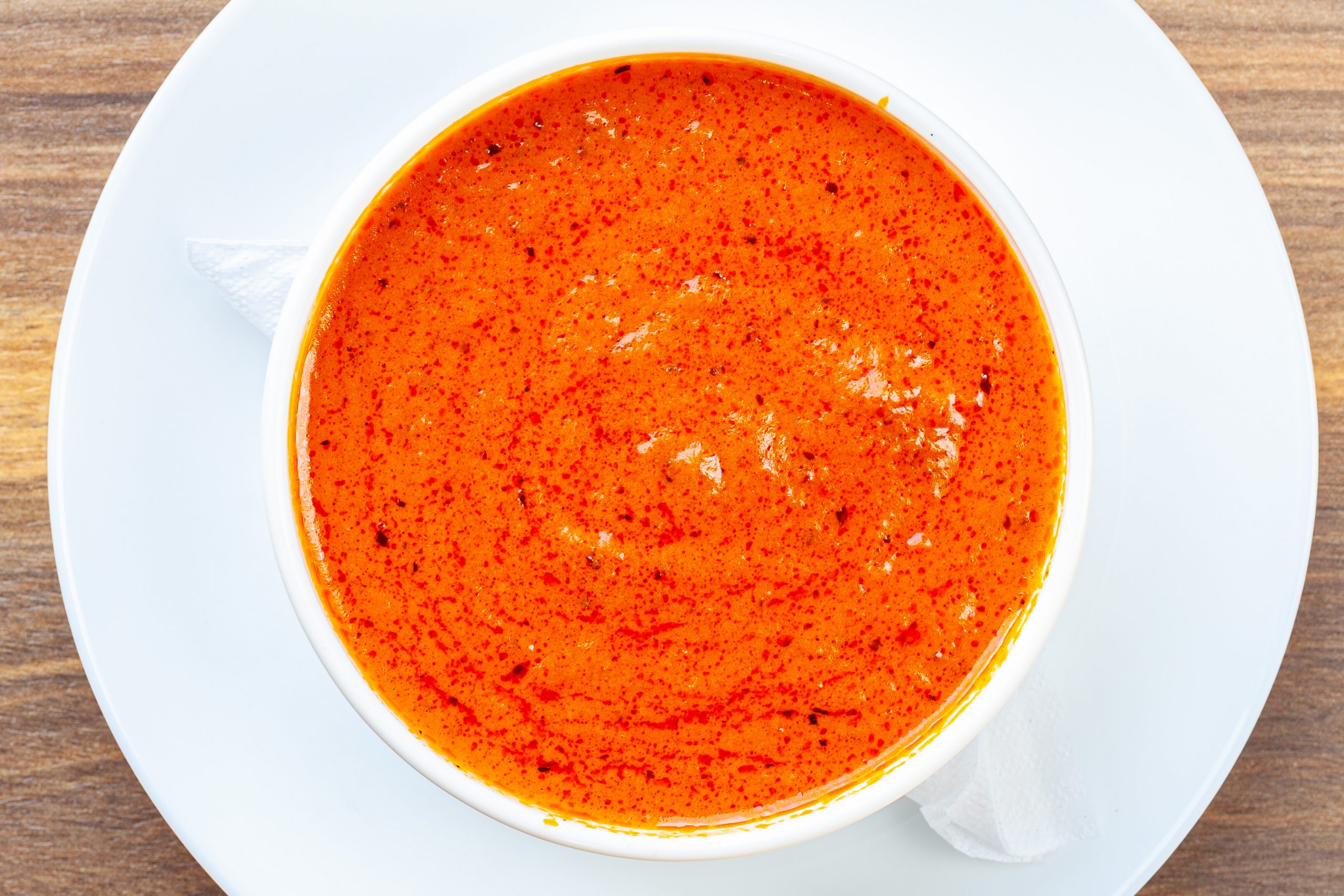 Side tomato, roasted red pepper and Gouda soup in a bowl