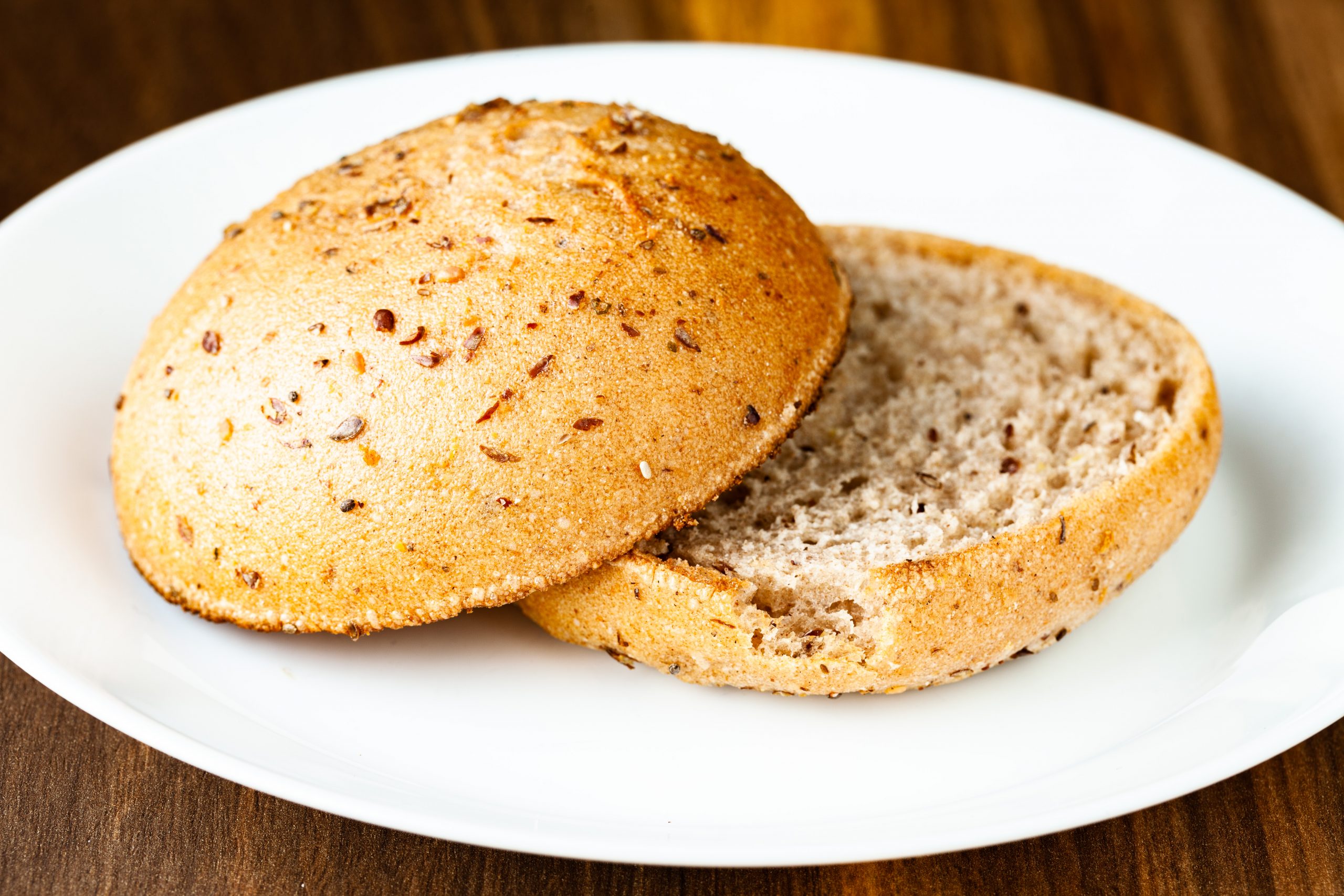 A sliced Care Bakery vegan and gluten-free hamburger bun from Prairie Dog Brewing, viewed from the side.