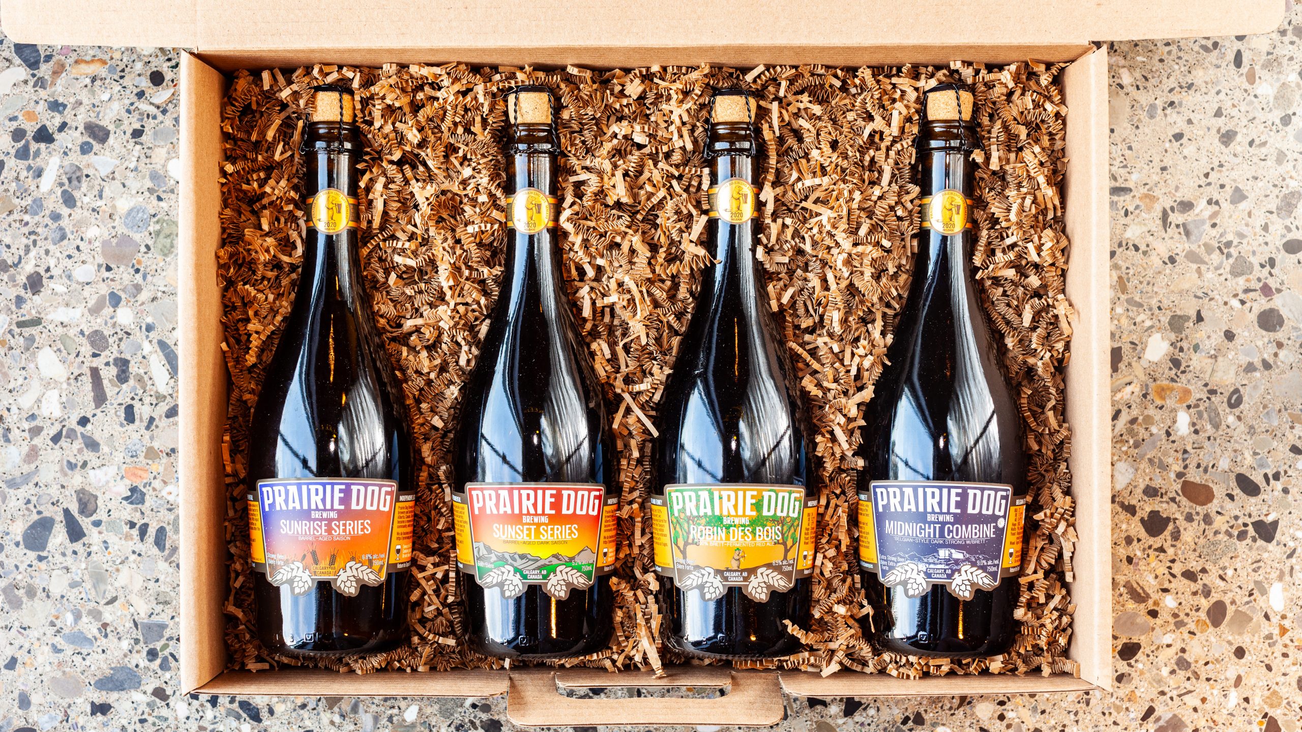Prairie Dog Brewing For the Love of Bottles Holiday Gift Box Set, with our Sunrise and Sunset Series barrel-aged saisons, our Robin des Bois barrel-aged brett-fermented red ale, and our premiere 2020 release of Midnight Combine, a barrel-aged Belgian-style strong dark ale.