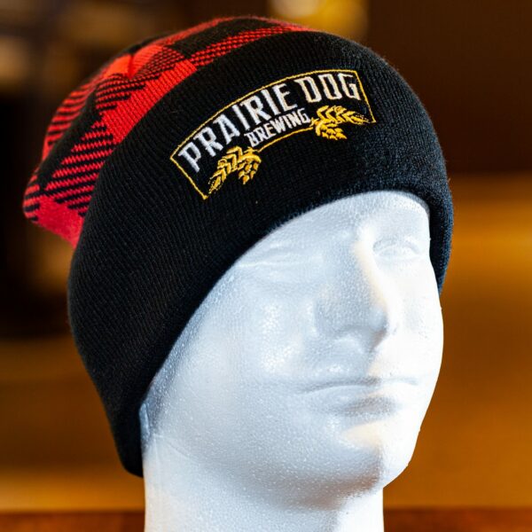 A red lumberjack-style toque with a black brim and embroidered Prairie Dog banner on the brim. Unisex. 1-size fits all.
