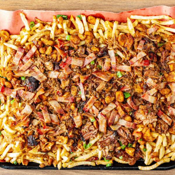 Prairie Dog Brewing's popular Extreme Poutine loaded up with house-cut kennebec fries, Crystal Springs cheese curds, slided bacon, beef gravy, nacho cheese, and green onions.