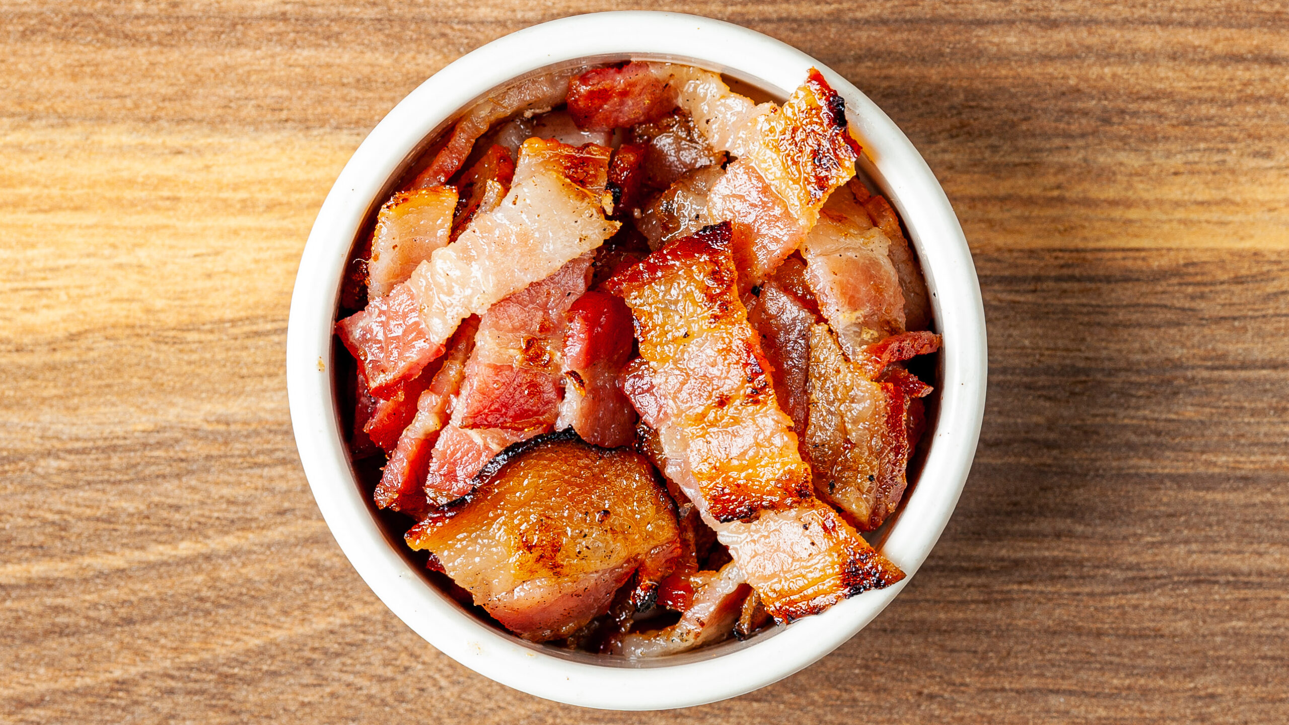 A side ramekin filled with Prairie Dog Brewing's delicous sliced bacon, served as an add-on.