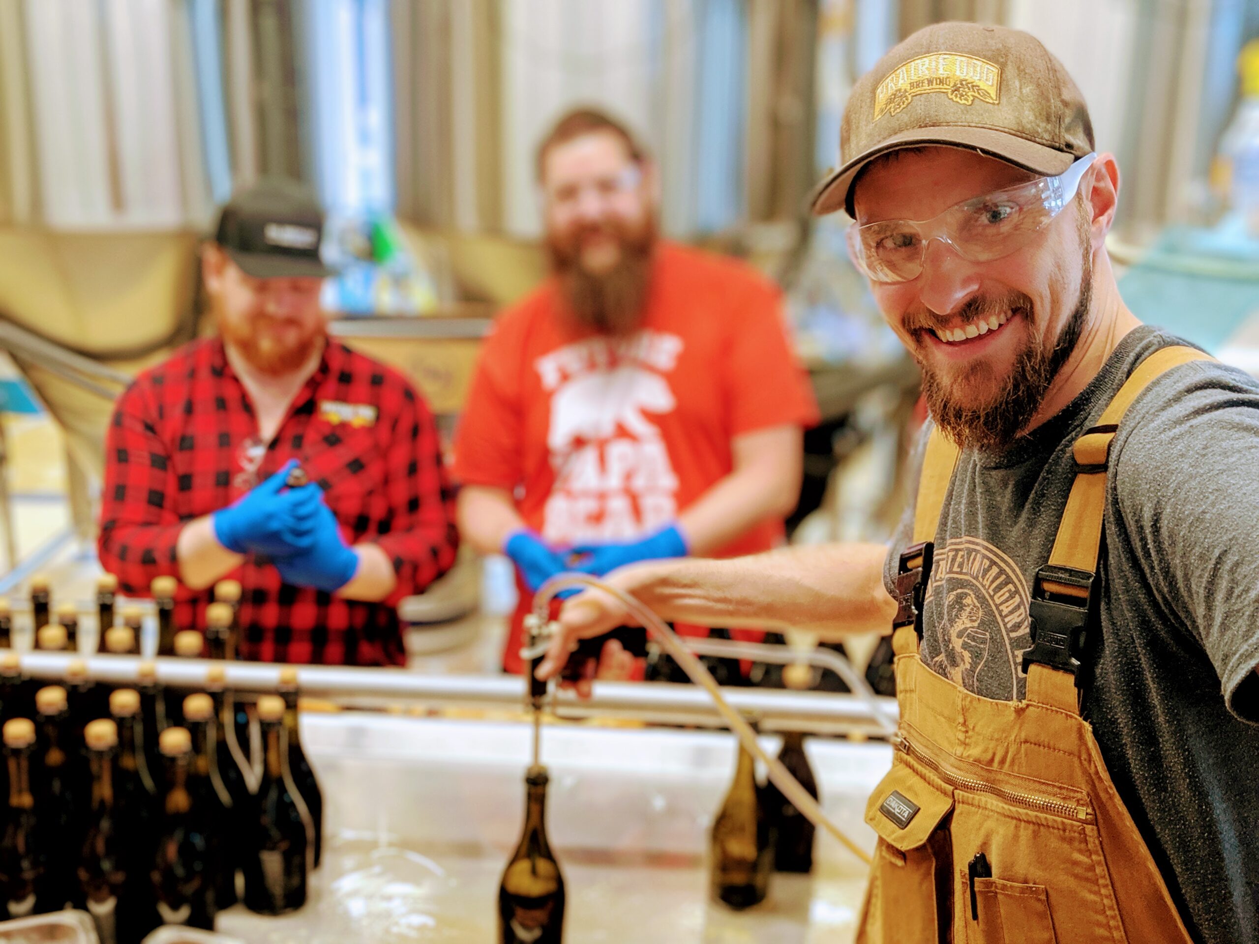 Founder Tyler taking a selfie on the bottling line of Midnight Combine 2019, with helpers in the background.