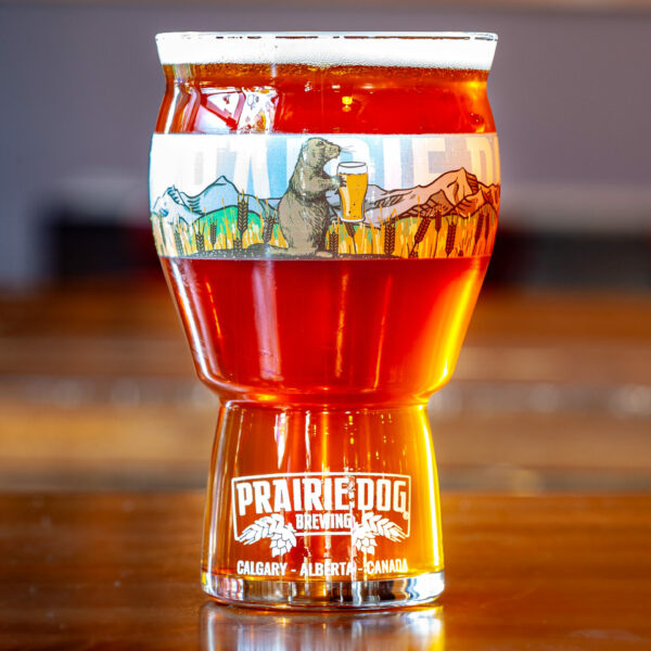 Prairie Dog Brewing Tail Twitcher IPA in a 16oz (473mL) branded beer glass.