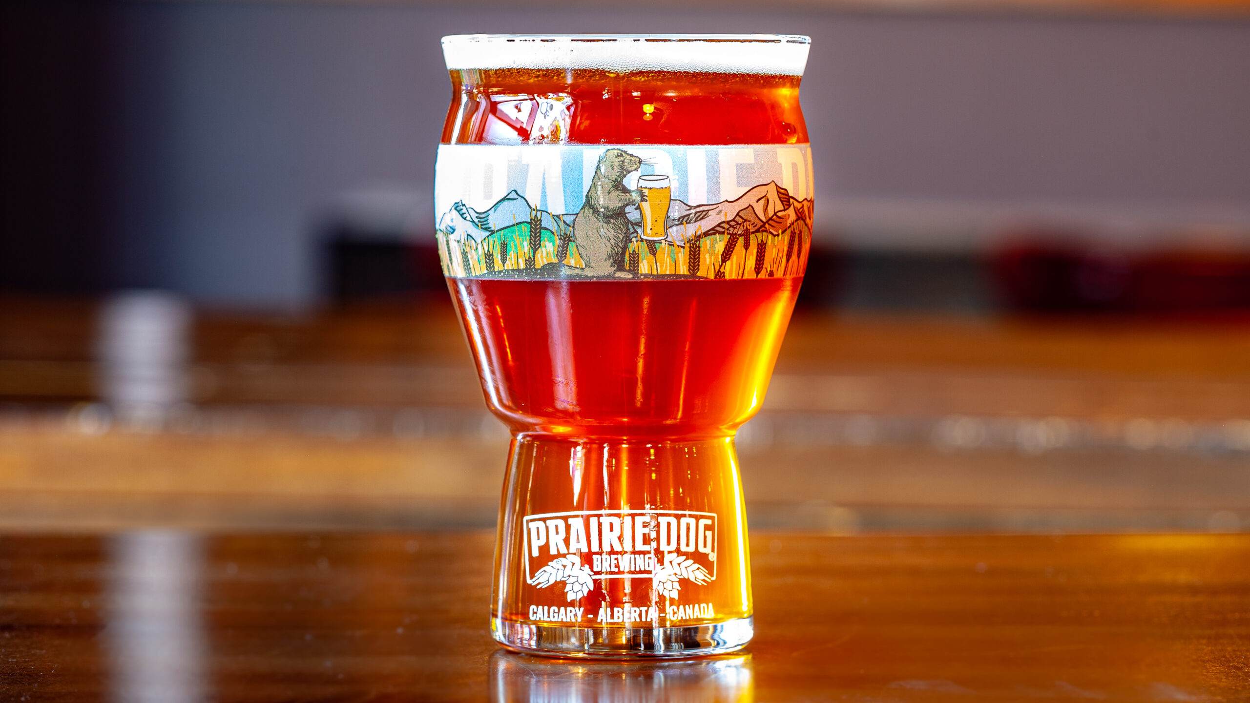 Prairie Dog Brewing Tail Twitcher IPA in a 16oz (473mL) branded beer glass.