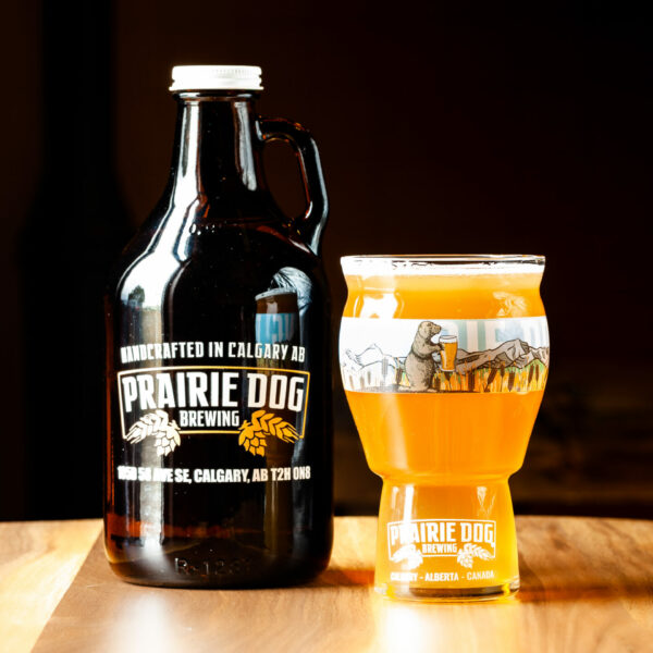 A 946mL howler jug of Prairie Dog Brewing Kettle Sour Gone Wild! with a 473mL draft pour in a branded beer glass.