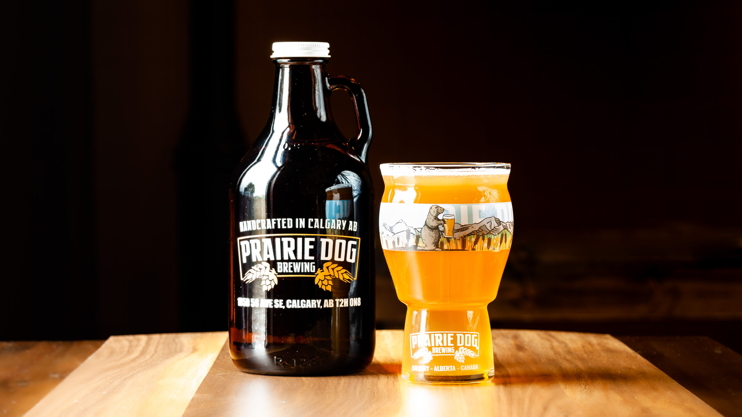 A 946mL howler jug of Prairie Dog Brewing Kettle Sour Gone Wild! with a 473mL draft pour in a branded beer glass.