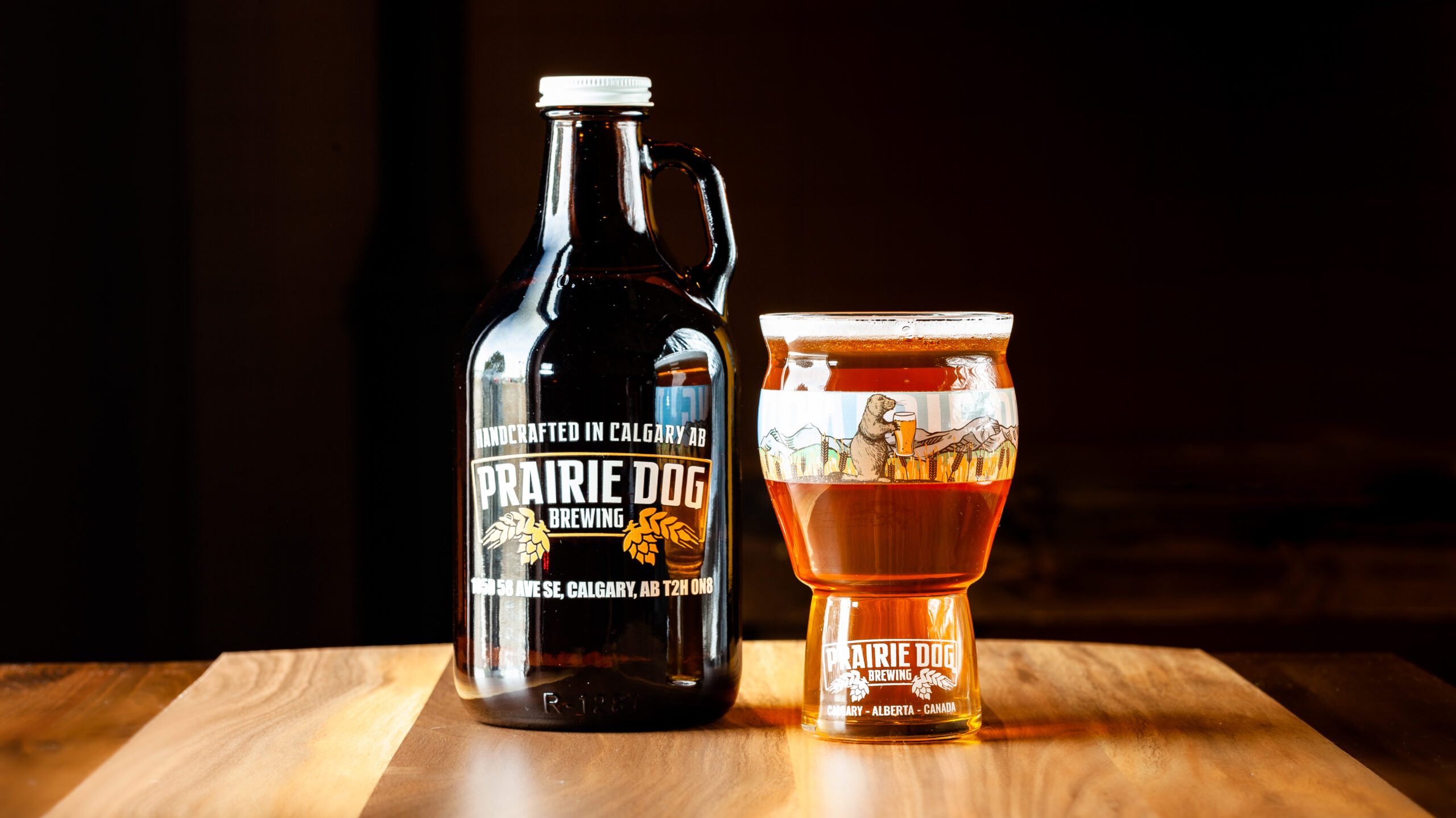 A 946mL howler jug of Prairie Dog Brewing's Super B wheat beer with a 473mL draft pour.