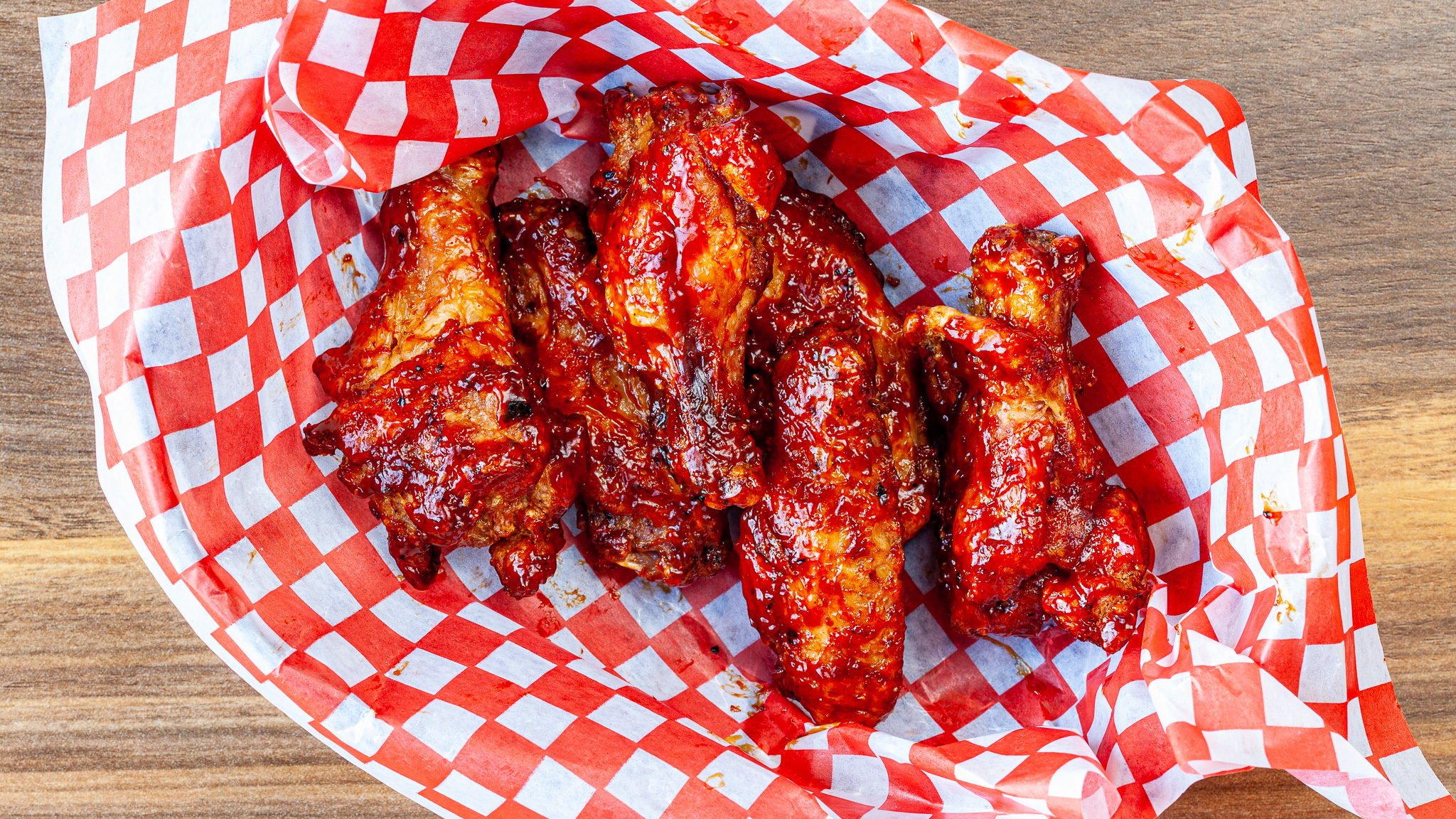 Prairie Dog Brewing's Smoked Chicken Wings - Regular size with 6 large, sauced or rubbed Canadian chicken wings, shown in a dine-in basket.