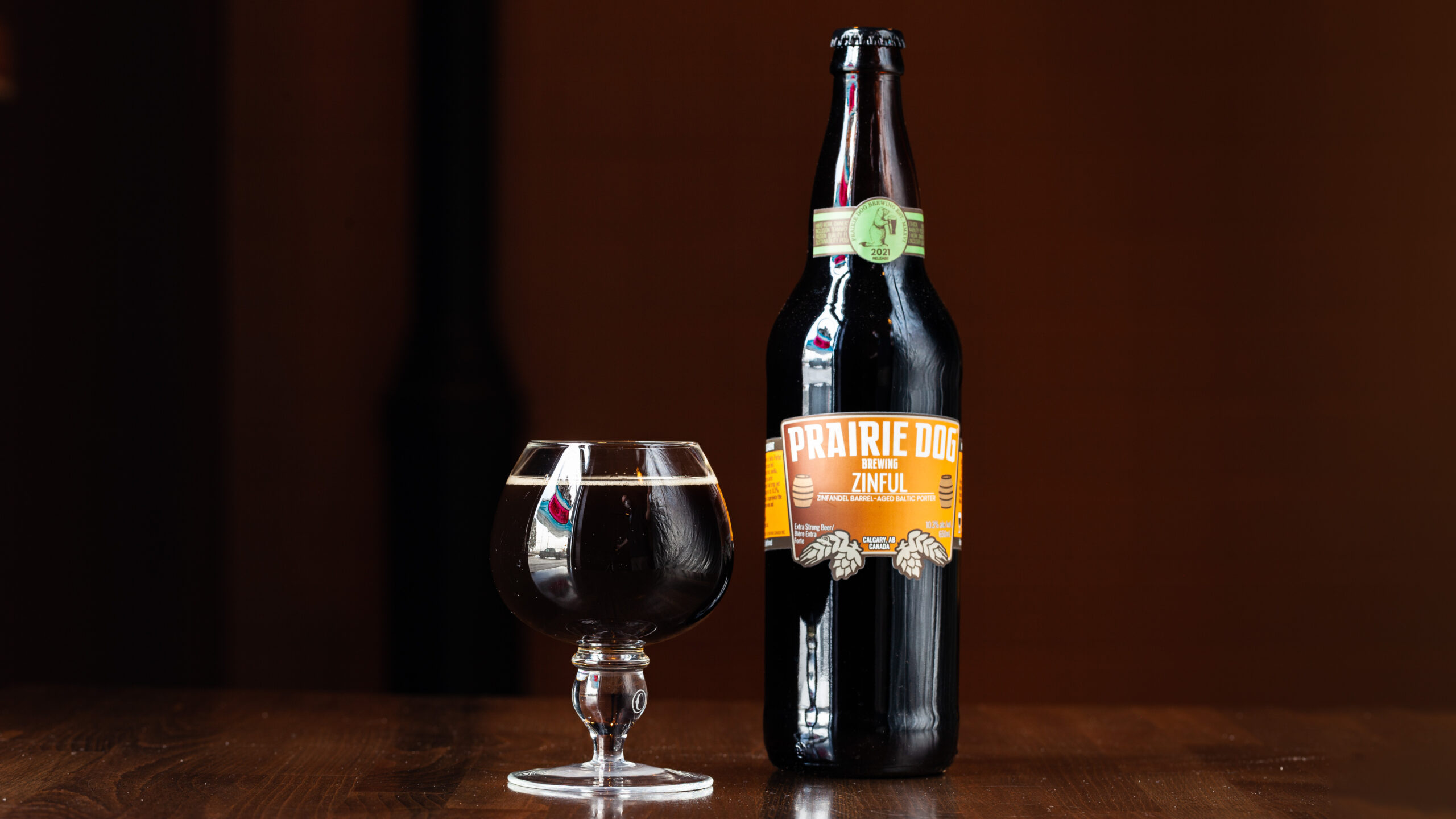 A 10oz pour and 650mL bottle of Zinful, Prairie Dog Brewing's 100th batch baltic porter aged for one year in a California Zinfandel (2018) barrel, adding mellow and slightly fruity notes to this rich and decadent beer