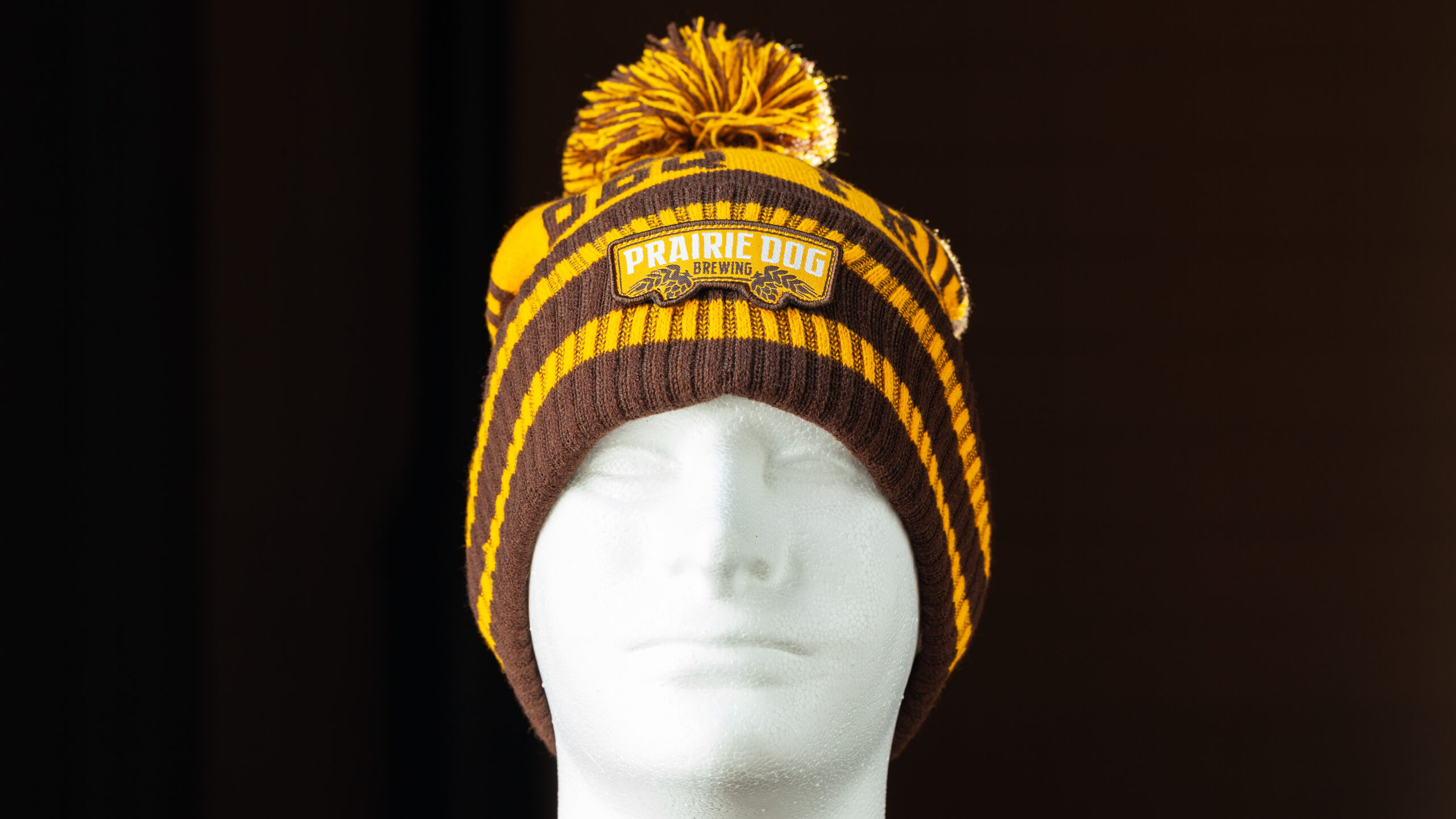 Brown and Yellow Prairie Dog Brewing PomPom Toque/Beanie This Prairie Dog® Brewing toque is the perfect addition to any outfit (we think it may even jazz up a suit and tie!. The earth tones are reminiscent of the prairie lands and ingredients used to make the craft beer we all know and love while the slogan gives a nod to your favourite local brewery and lets everyone know what you like.