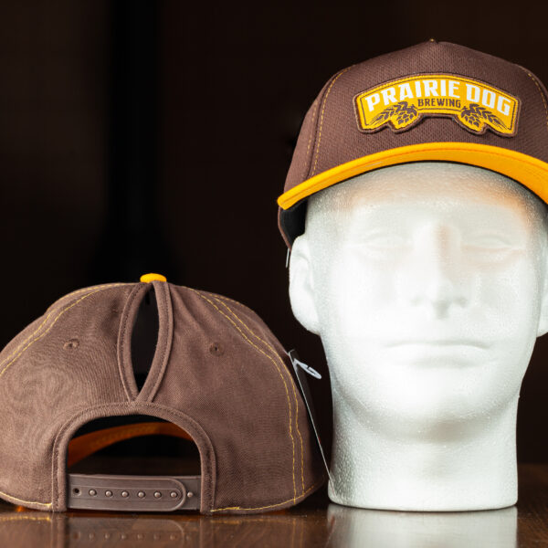 This Prairie Dog® Brewing hat is the perfect addition to any outfit. Prairie Dog Brewing brown and orange-yellow colours. The slogan gives a nod to your favourite local brewery and lets everyone know what you like. A high notch in the top of the hat allows for a high ponytail to come out the top of the hat.