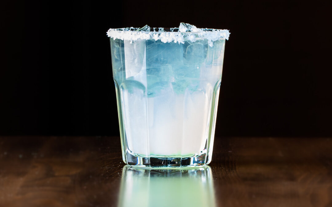 A short highball glass filled with Prairie Dog Brewing's Classic Margarita tequila based cocktail, featuring a kosher salt rim.