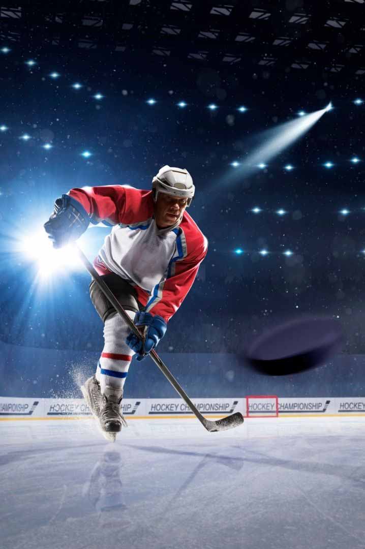 Hockey Player On Ice Shooting An NFL league hockey player shoots the puck in a stadium.