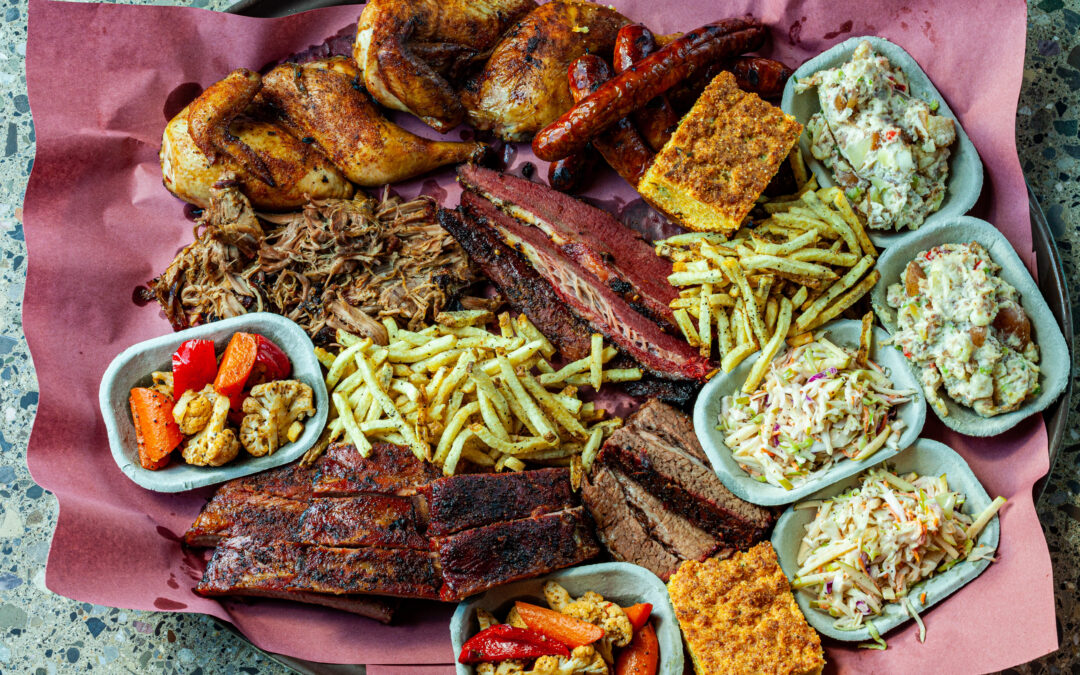 A huge platter full of Prairie Dog Brewing's signature BBQ combo The Fuller Pit featuring brisket, pastrami, pulled pork, pork side ribs, smoked chicken, chorizo sausages, fries, cornbread and sides.