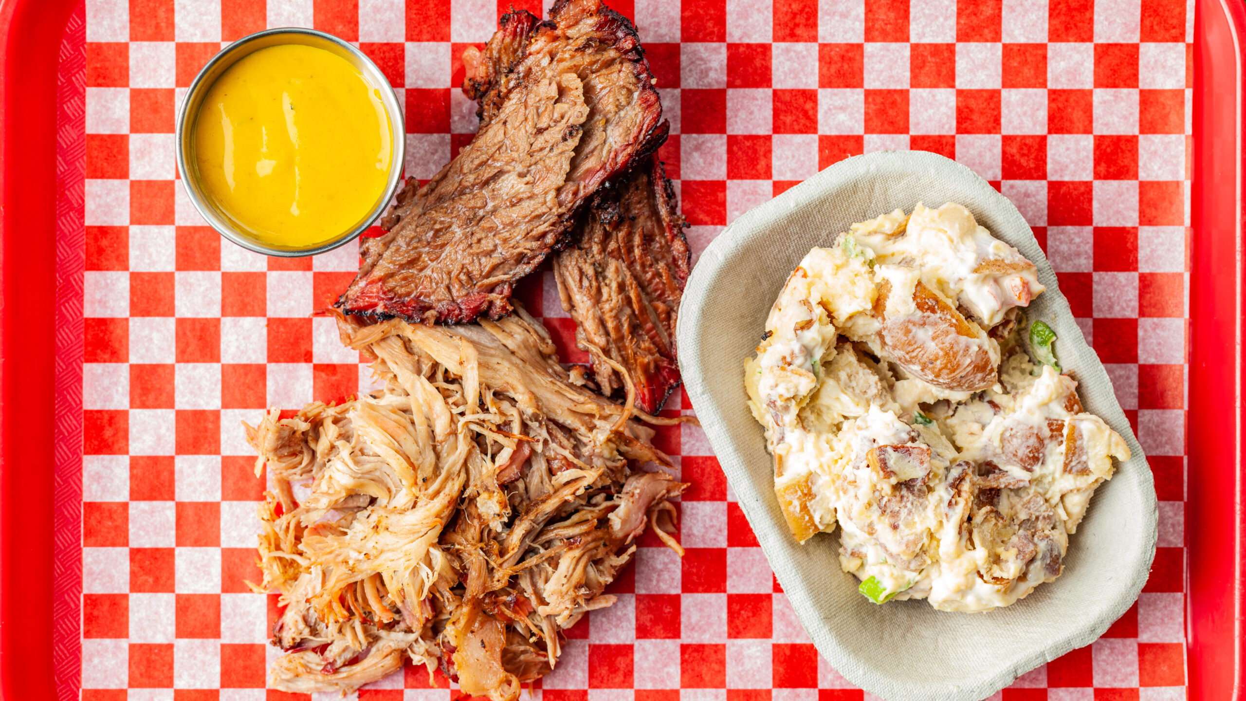 A top down view of Prairie Dog Brewing's Lunch Platter consisting of two meats, a side and one sauce.