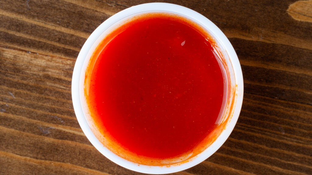 A 2 oz portion of Prairie Dog Brewing's Mango Habanero Hot Sauce served in a white ramekin