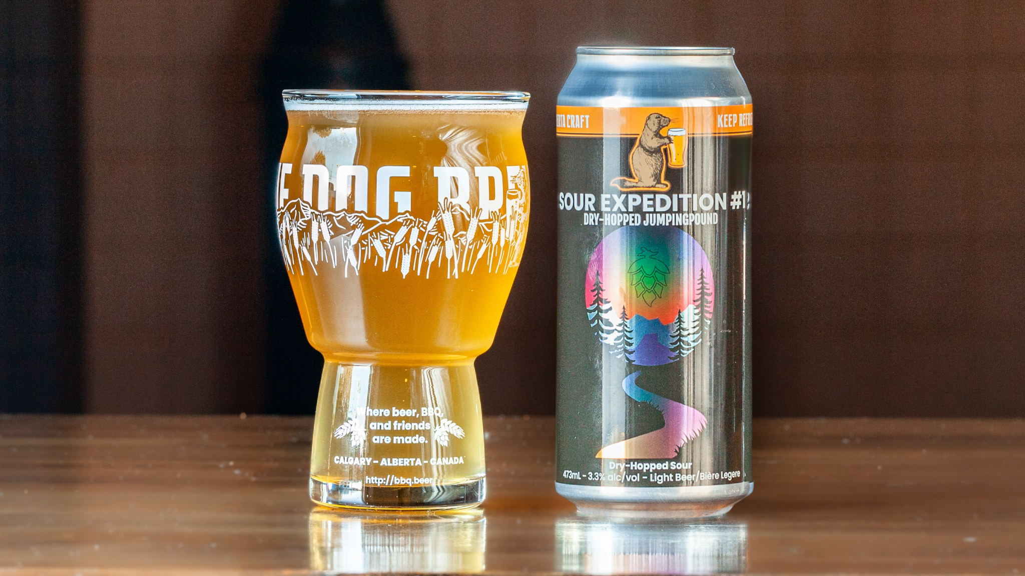 Sour Expedition 1 Can + Glass A 473-ml pint glass of brightly coloured beer next to a can of Prairie Dog Brewing You're Beautiful Blueberry Lemon Sour Beer in full colour wrapped label.